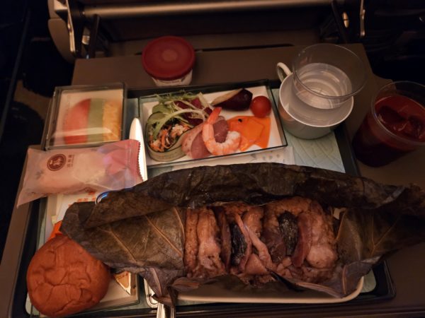 Airplane meal showing chicken and rice wrapped in a lotus leaf.